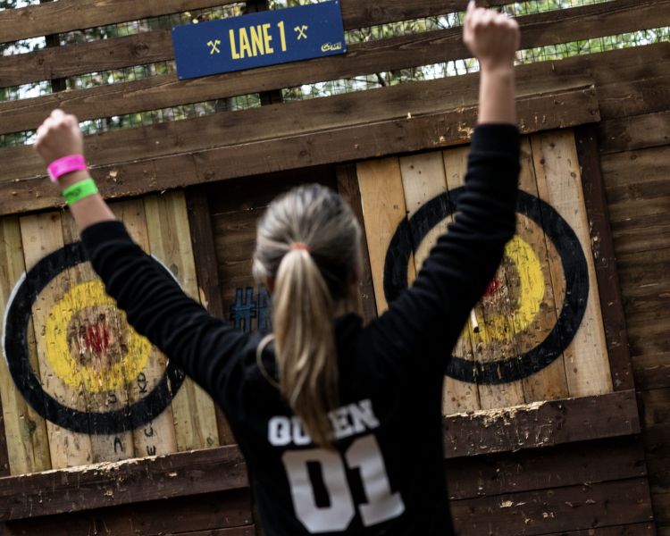 girl celebrating an axe throw at go ape axe throwing experience