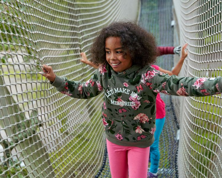young girl walking through net tunnel on go ape nets adventure