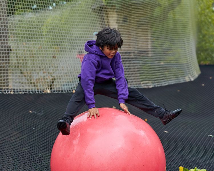 young boy playing on bouncy ball on nets adventure at go ape