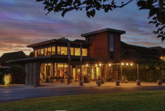 the exterior of q hotels norton park lit up at night