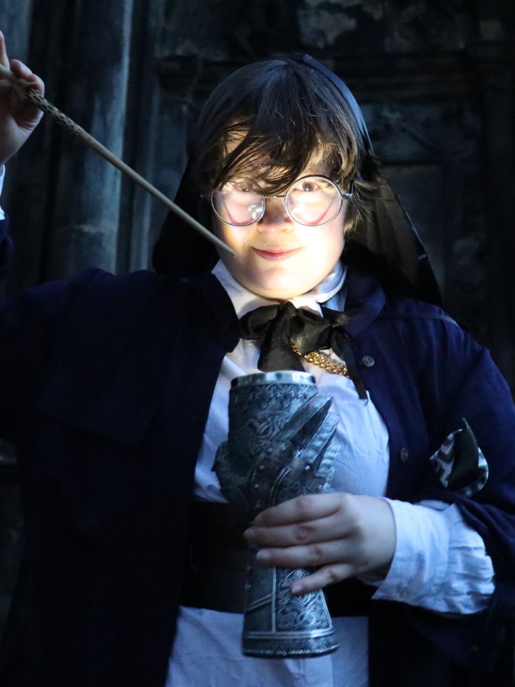 person dressed as a wizard casting a spell with the wand they have created at the school of magic in edinburgh