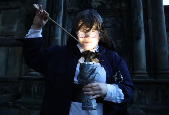 person dressed as a wizard casting a spell with the wand they have created at the school of magic in edinburgh