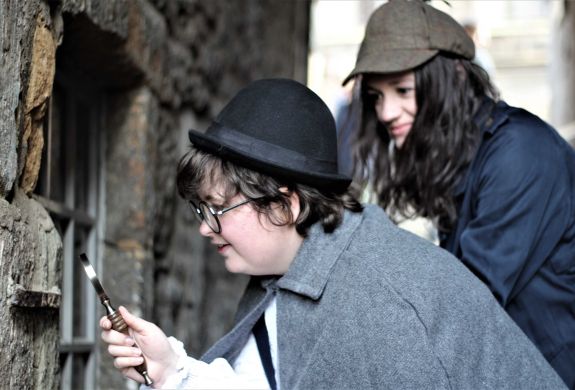 2 people dressed as sherlock holmes looking for clues on a sherlock holmes experience day in edinburgh