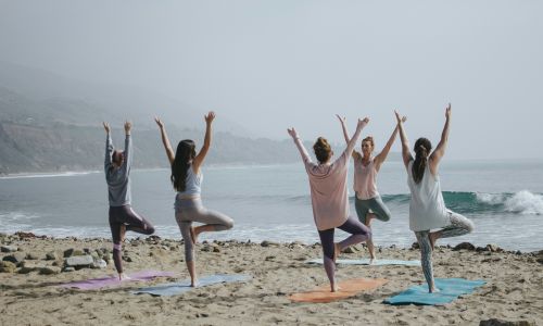Women doing yoga on beach