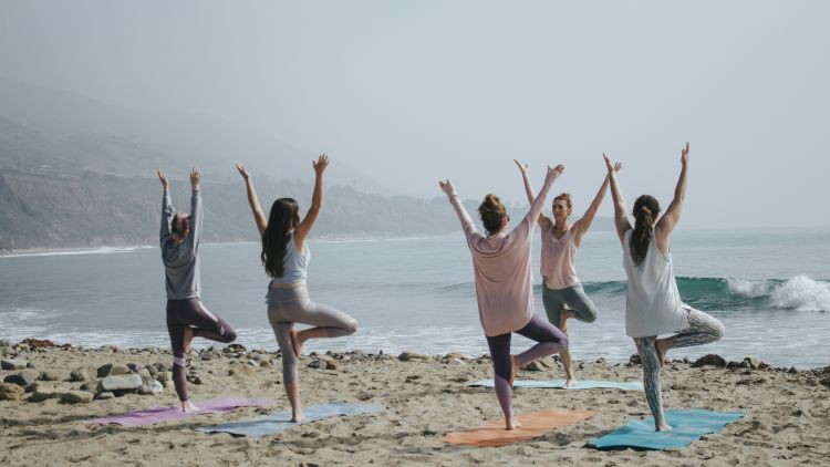 Women doing yoga on beach