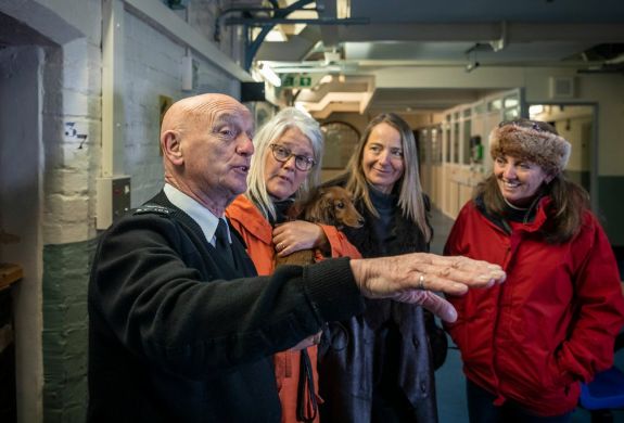 three ladies listening to a guide on a guided tour of a former prison experience day