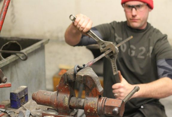 Man twisting hot metal in a vice
