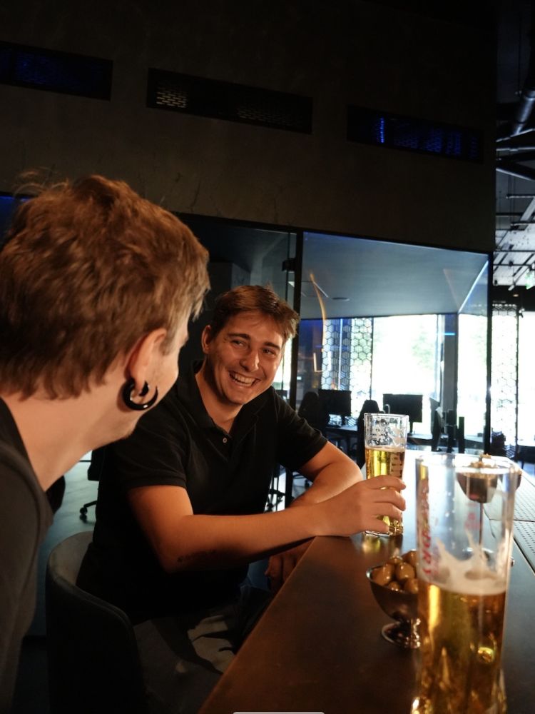 two friends chatting at the bar over drinks at gaming bar in london