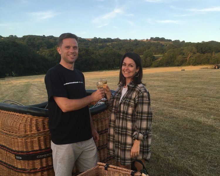 Couple toasting with champagne upon balloon landing