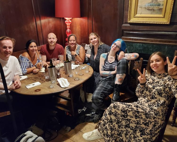 people sitting around a bar table on a london street art and food taste of diversity tour
