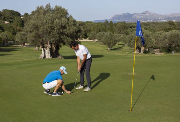 Man receiving golf tuition on a golf course