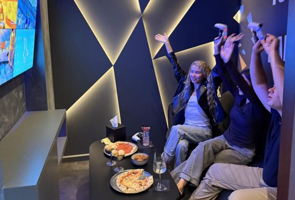 three people playing playstation at gaming bar in london