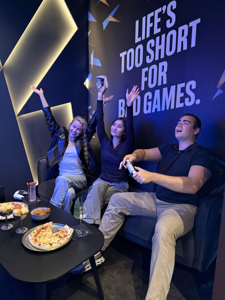 people having fun playing playstation games at gaming bar in london