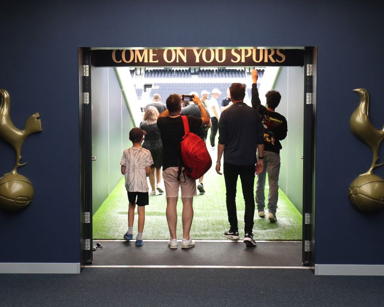 visitors walking through the tunnel to the pitch on the tottenham hotspur stadium tour in london