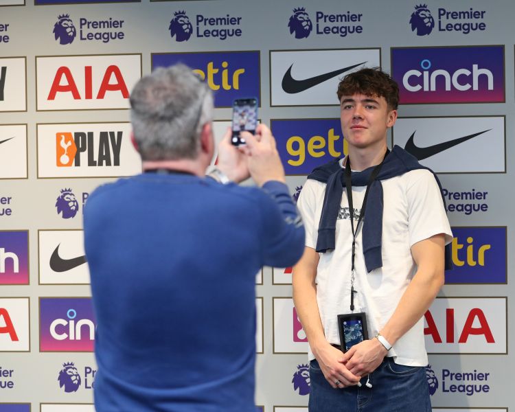 visitors having their photo taken on the tottenham hotspur stadium tour in london