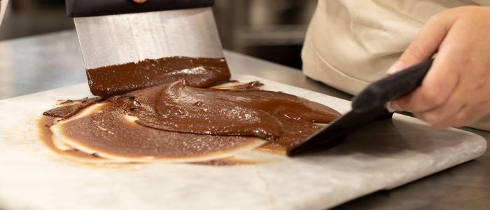 chocolate being tempered on a marble surface