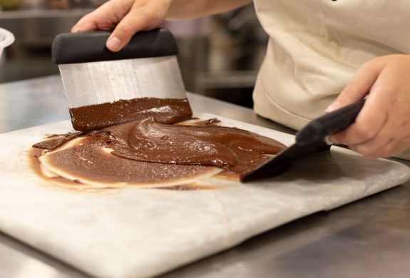 chocolate being tempered on a marble surface
