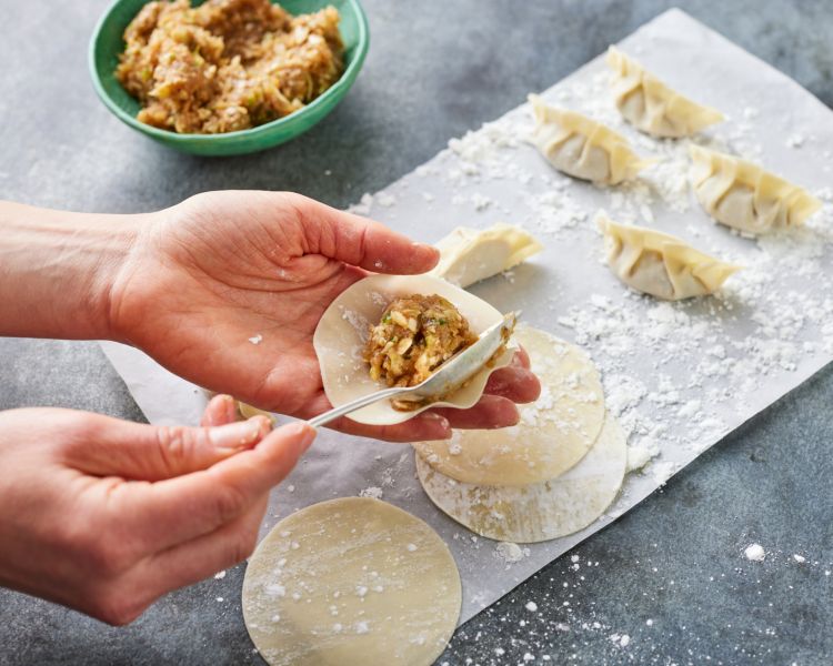 japanese gyoza being filled at jamie oliver cookery school class