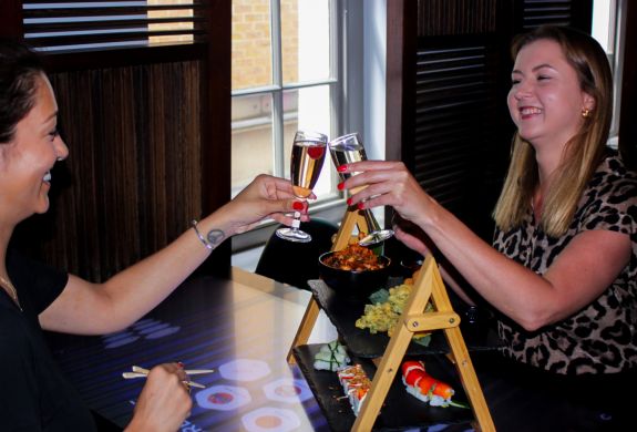 Two ladies saying cheers with fizz at asian afternoon tea