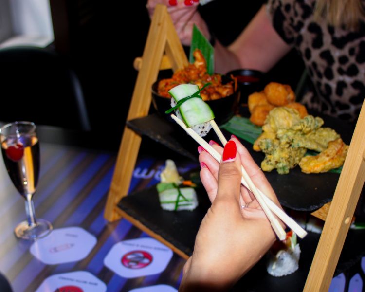 Close up of food held in chopsticks at asian afternoon tea