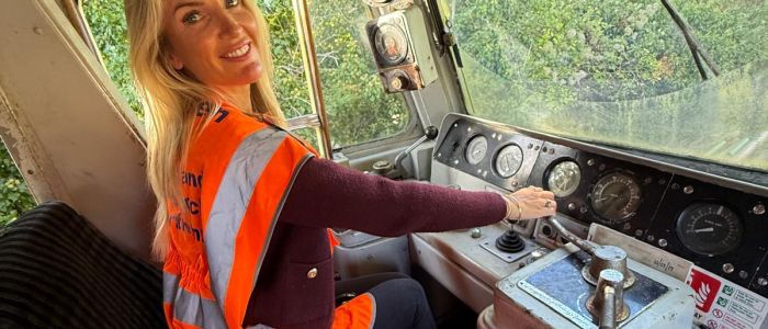 woman sitting in drivers seat of diesel train on a train driving experience
