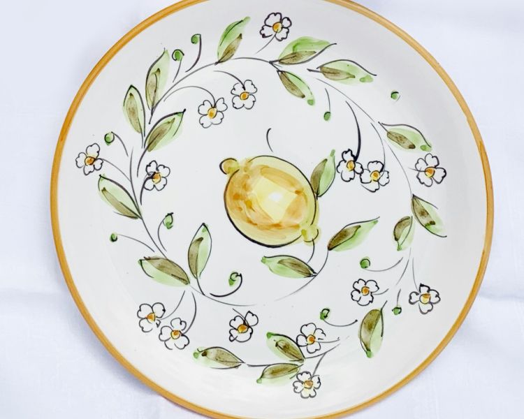 plate painted in a design with lemons and leaves