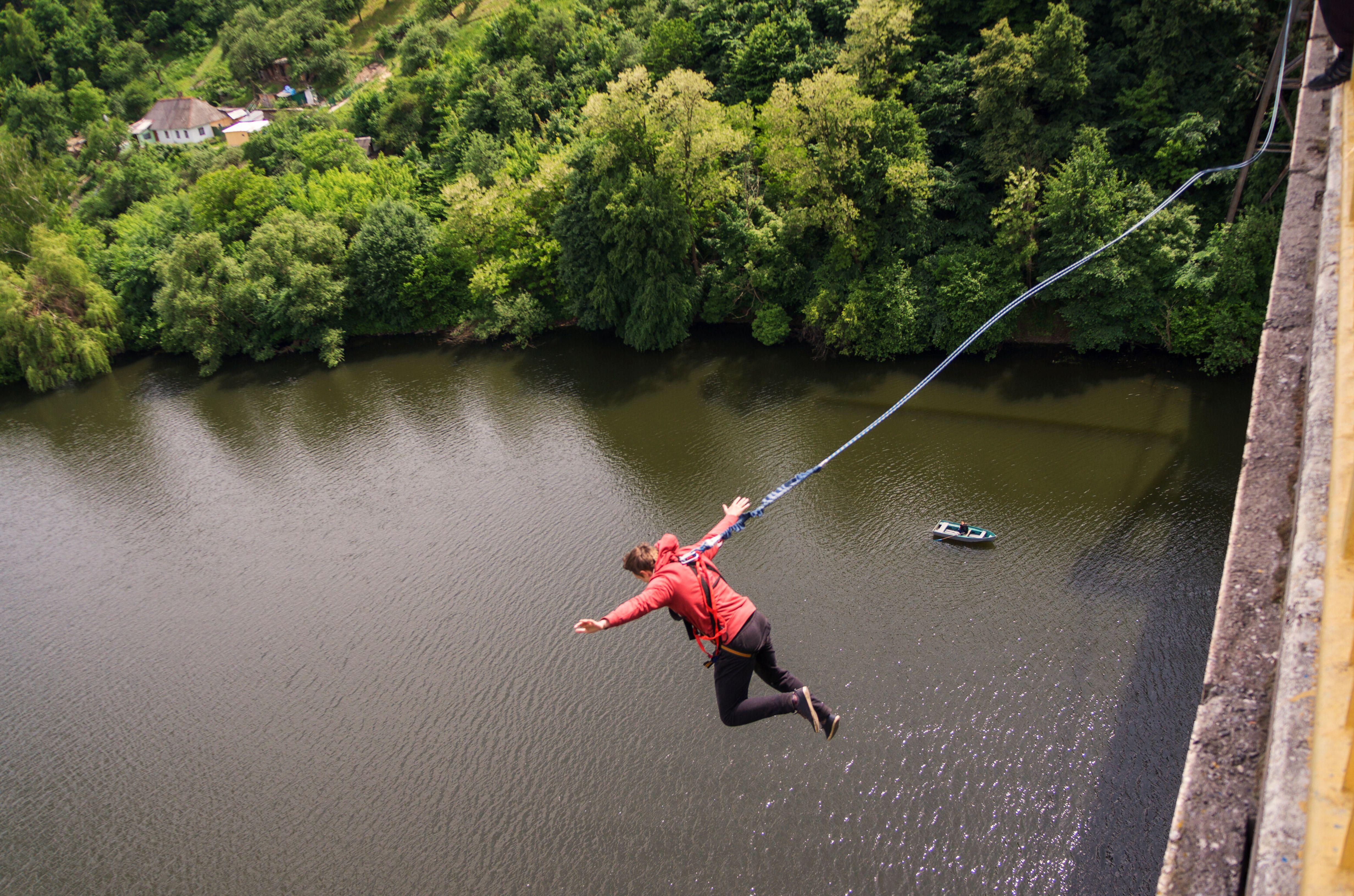 Man bungee jumping over river