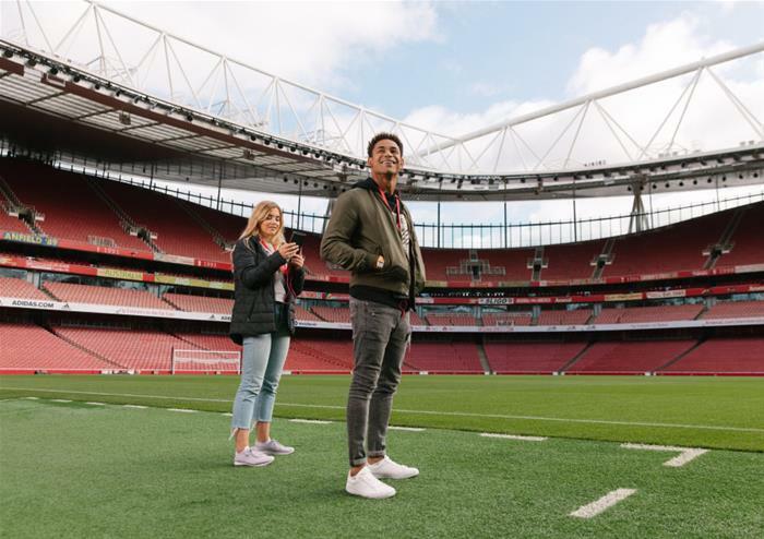 visitors on the pitch on the arsenal emirates stadium tour in london