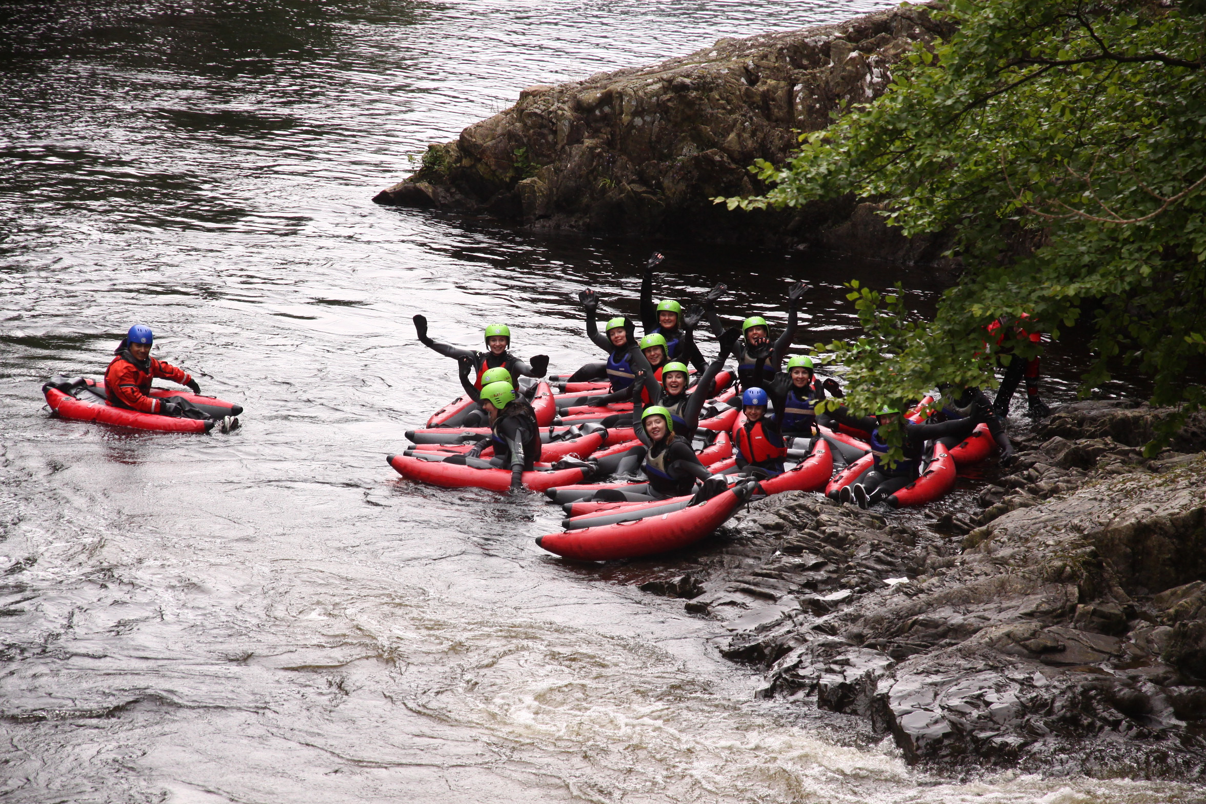 group of people on the side of a river getting ready for a river bugging experience on the river tummel in scotland