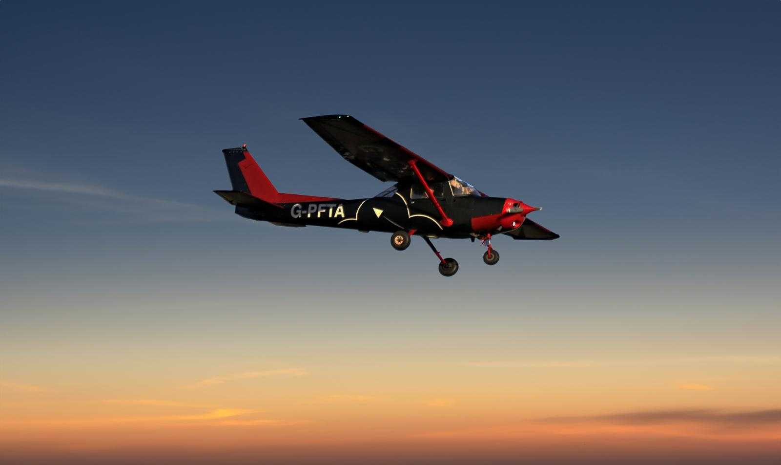 a small aeroplane in the sky against a sunrise for a plane flying lesson experience