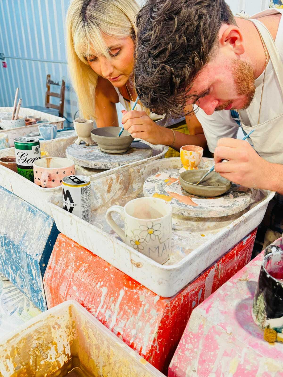 two people painting pottery on a pottery painting experience in london
